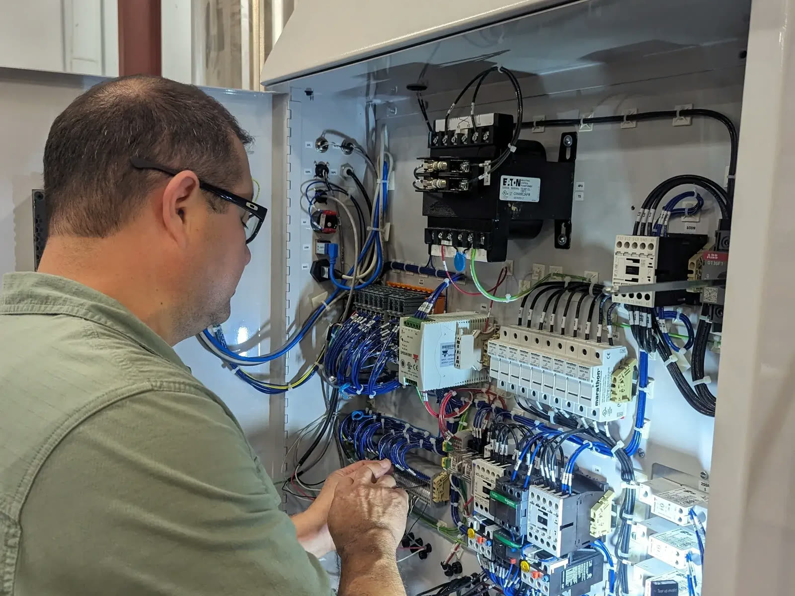 A technician wiring a control cabinet
