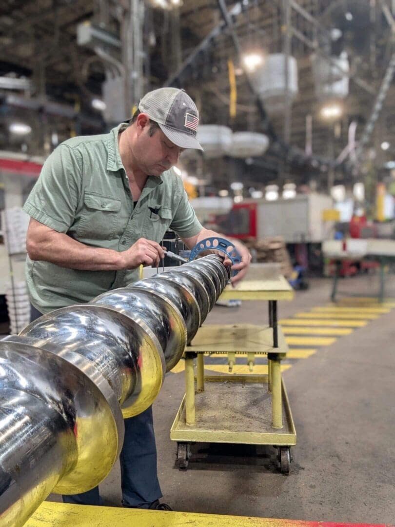 A Plasticset technician measuring the flights of a large injection screw