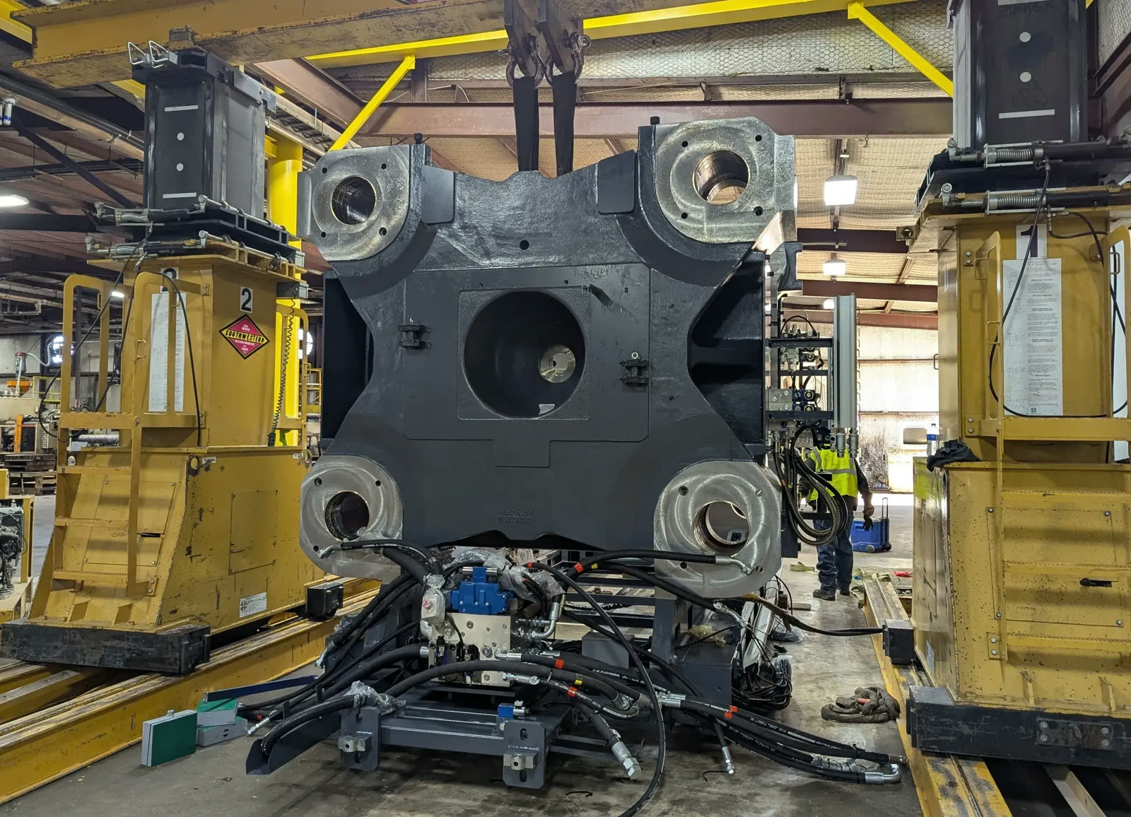 A large platen being moved with a hydraulic gantry during a machine relocation